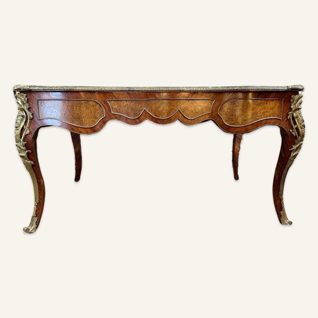 This Louis XV style bureau plat is 19th century reproduction, likely Napoleon III, of high quality. Marquetry and burl-...