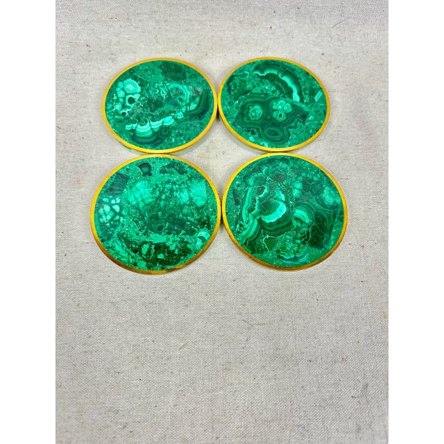 Stunning set of malachite stone coasters. Set of 4. Each coaster is made of a slice of malachite stone wrapped in brass....