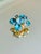 1960s dimensional Maltese cross brooch featuring a highly raised, multi tiered cluster of emerald green, teal, aqua, and...