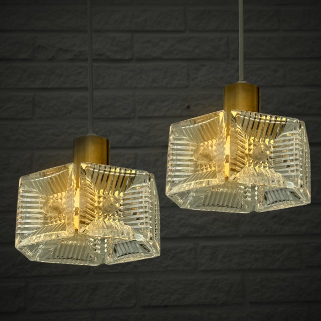 A pair of Mid-Century Modern pendant lamps designed by Carl Fagerlund for the Swedish glassworks Orrefors in the 1960s....