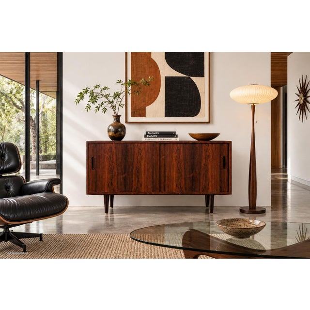 Designed by Carlo Jensen for Poul Hundevad in Denmark during the 1960s, this Danish modern credenza / sideboard is a...