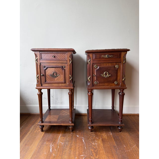 This exquisite 19th Century mahogany nightstand features a polished marble top and intricate bronze decorations. Its rich...