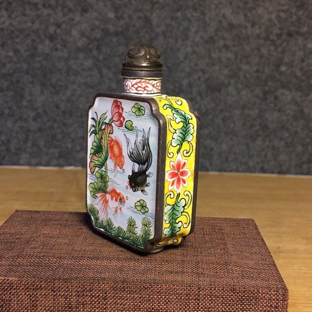 This is a charming vintage Chinese snuff bottle, crafted from copper with painted enamel (huafalang) decoration. The...