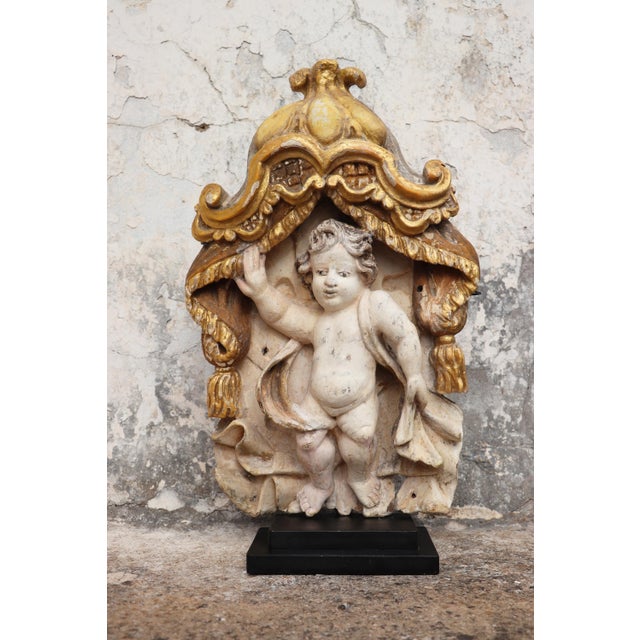 Cherub Angel within a baldachin, 18th century, Portuguese, mounted on an iron base. For transport, the angel will be...