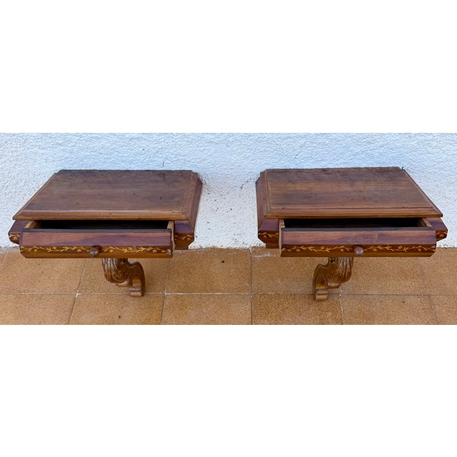 Elegant pair of Spanish wall-mounted nightstands crafted in wood, featuring a refined and highly decorative design. Each...