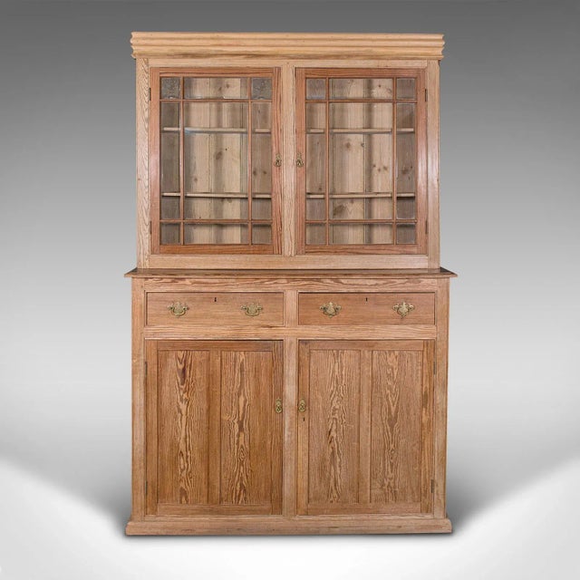 This is a very tall antique glazed cupboard. An English, pine sideboard dresser or larder cabinet, dating to the early...