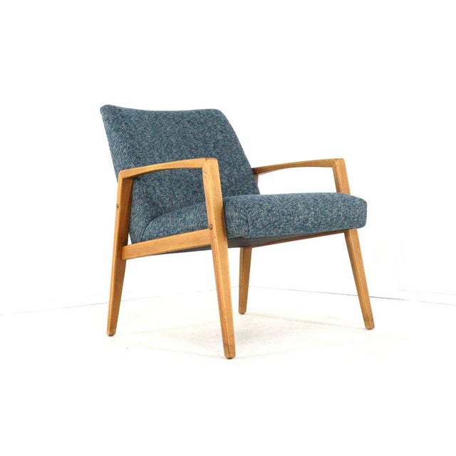 A compact and unique armchair from Germany! With its beautiful solid wood frame and its elegantly shaped, sleek armrests...