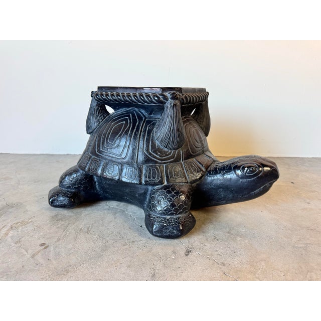 Charming and sculptural, this Hollywood Regency-style turtle plant stand is crafted from ceramic pottery with a black...