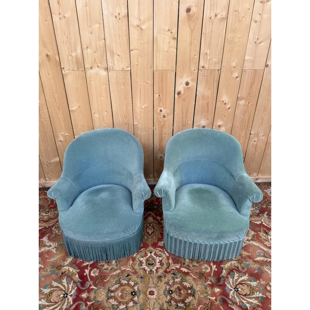 A pair of faux toadstool armchairs, fully upholstered in duck-egg blue velvet, with the characteristic rounded, enveloping...