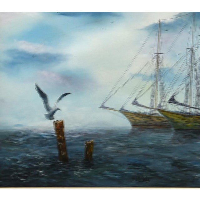 This serene oil on canvas depicts a maritime scene featuring three elegant tall ships, likely schooners, gently moored on...