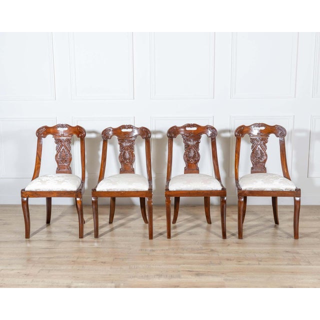 A graceful set of four Lombard gondola chairs from the first half of the 19th century, finely crafted in solid walnut....
