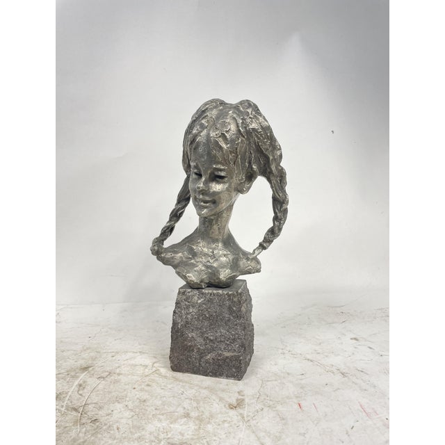 Beautiful and antique metal sculpture with a stone base by the French sculptor E. Patris. The sculpture depicts the face...