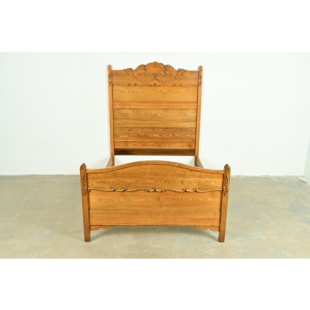 A gorgeous antique Victorian carved oak full size bed frame In the manner of Widdicomb USA, Circa 1890s Measures: 56.75"W...