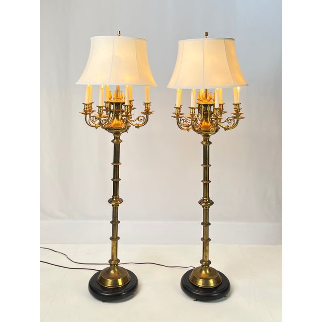 Exceptional pair of Neoclassical multi-light candelabra floor lamps. Crafted with solid brass baluster stems, turned...