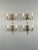 An elegant set of four bronze wall sconces in the Louis XVI style. Each sconce features two delicately curved arms adorned...