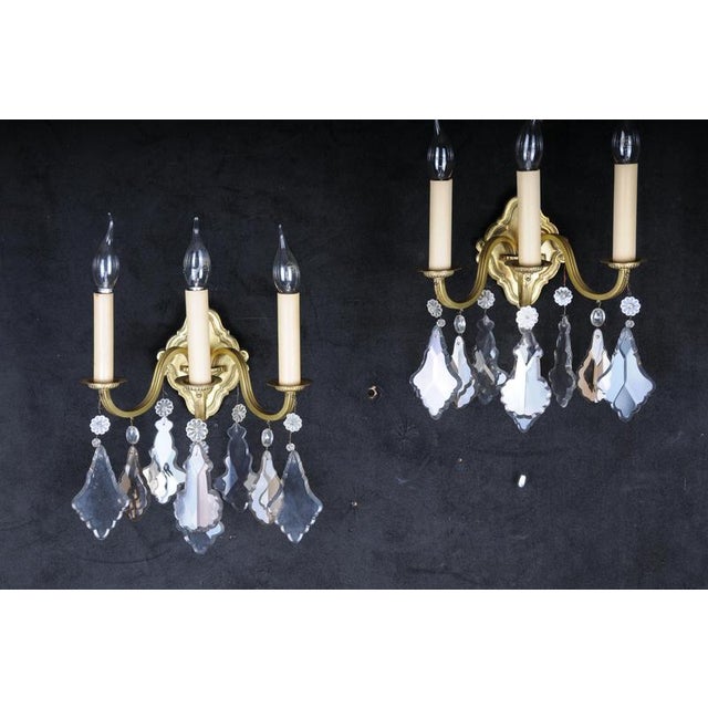 Pair (2) of classic French crystal sconces, 20th century. Brass and gold sconces, each with three curved arms and cut...