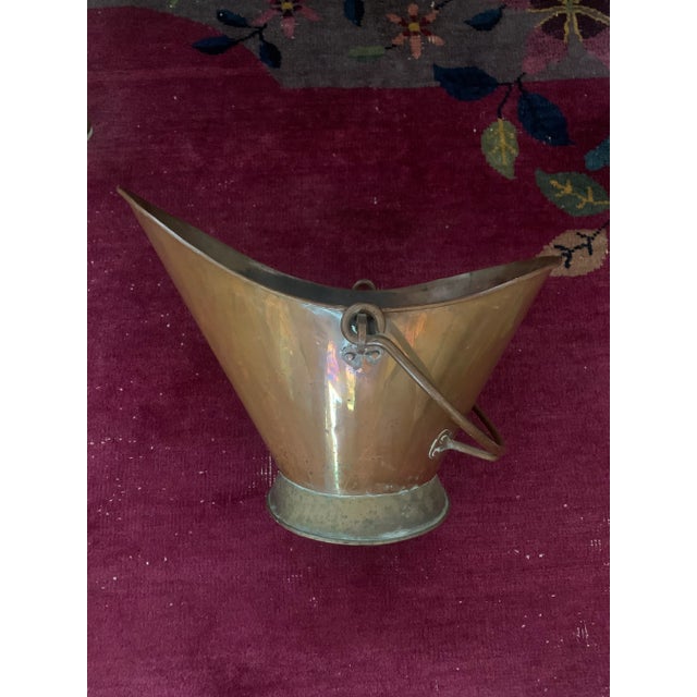 Antique copper coal scuttle. This is a very attractive scuttle with a copper swing arm and brass base. Measurements are:...