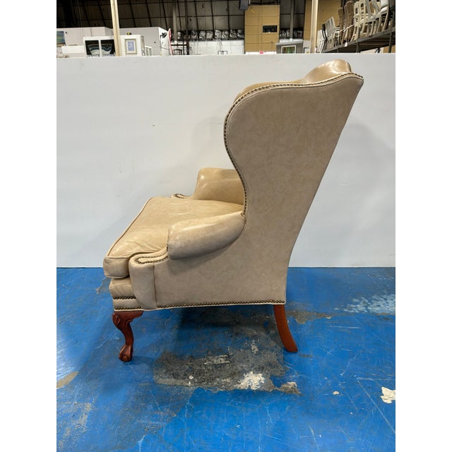 Stylish Ethan Allen Vintage Leather Wing Chair. Sand/Light Camel color leather, wood legs with nailheads around body....