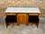 A French walnut enfilade from the 19th century with white marble top, three drawers over three doors and Doric pilasters....