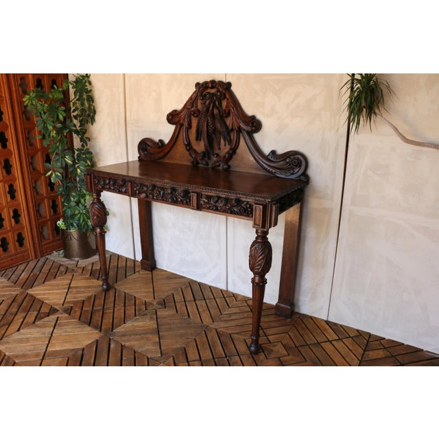 An exquisite console or hall table crafted from solid oak, showcasing the rich detailing of French design. This remarkable...
