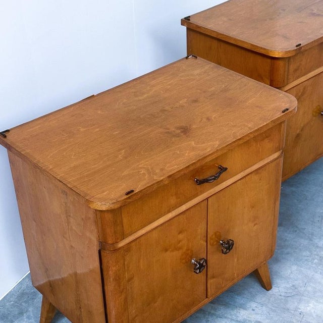 Charming pair of vintage mid-century bedside cabinets, dating from approximately the 1950s. Their compact proportions,...