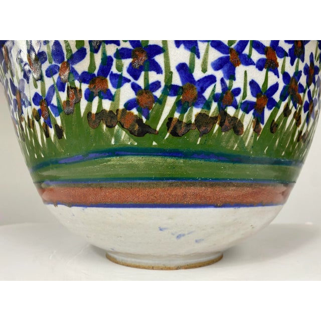 Beautiful large ceramic bowl with hand painted flowers that decorate the inside and outside of the bowl, signed Carris....
