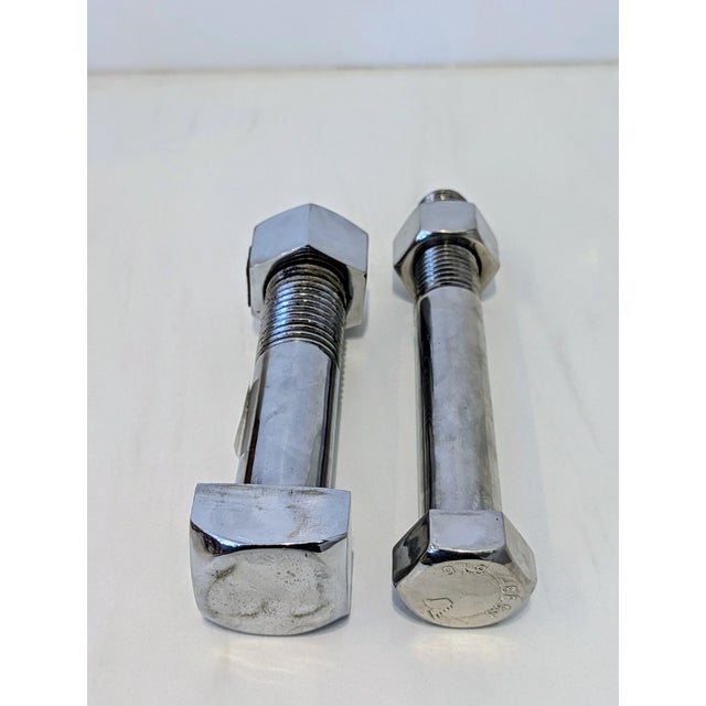 A pair of oversized industrial nut and bolt bookends, executed in polished chrome-plated metal. Dating to the 1970s–1980s,...