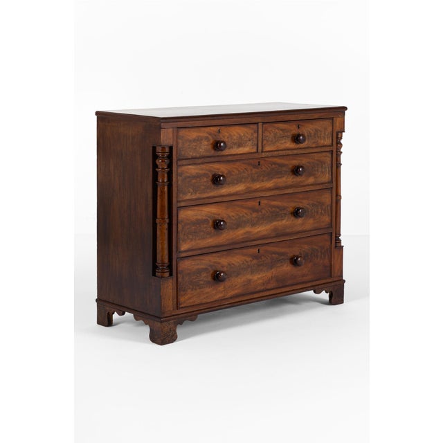 A wide Flamed mahogany Victorian chest of drawers with an arrangement of two over three long drawers. The smooth running...