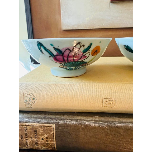 A charming pair of small antique Chinese Famille Rose porcelain bowls, beautifully decorated with colorful hand-painted...