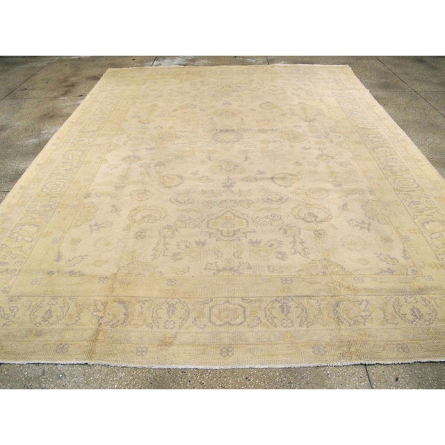An antique Turkish Oushak room size carpet. Light Oushaks, as here with an oyster tonality, never seem to go out of style....