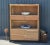 This rustic industrial bookcase features a live edge acacia slab top and an iron frame, offering a solid wood office...