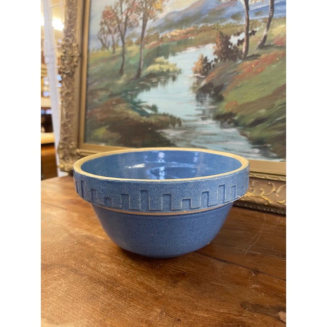 Vintage stoneware mixing bowl featuring a speckled blue glaze and a raised geometric band encircling the rim. The design...