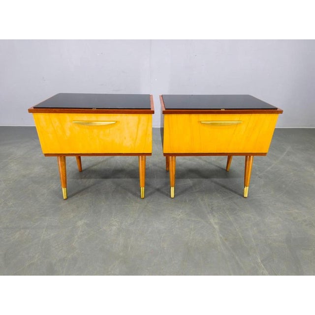 A striking pair of mid-century modern bedside tables from Czechoslovakia, dating to the 1960s. Crafted from a mix of woods...