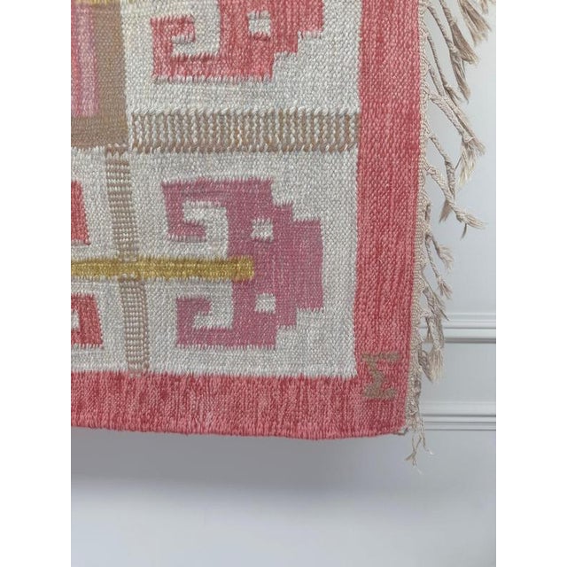 A beautiful mid-century Swedish rölakan flatweave in a warm palette of raspberry pink, coral, ivory and ochre. The...