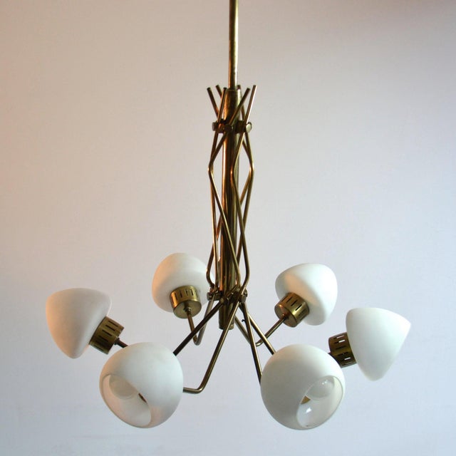 Stilnovo style 1950's Italian chandelier consist of 6 curved brass arms holding opaline shades. The stem is elegantly...