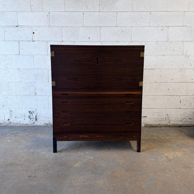 A striking Danish modern high chest by Svend Langkilde, crafted in richly figured rosewood during the 1960s. The cabinet...