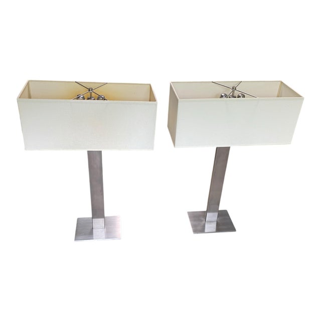 A pair of modern lamps in brushed steel with rectangular shades. Each lamp takes two bulbs. The lights can be turned on...