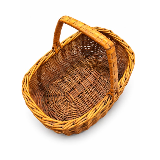 Add a touch of rustic charm to your home with this beautiful vintage handwoven wicker basket from the 1980s. Featuring a...