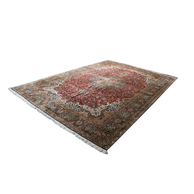 This authentic handmade Indian wool rug showcases an extraordinarily detailed, traditional layout anchored by a prominent,...