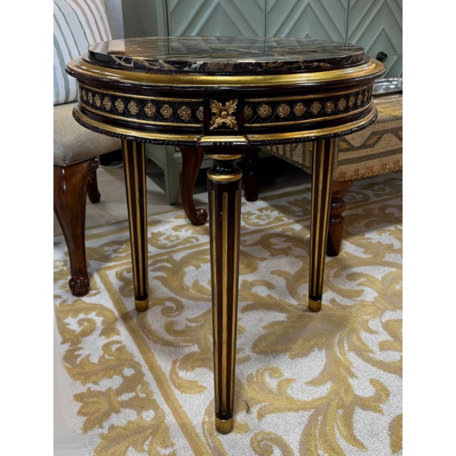 Louis SVI style side table by John Richard, featuring richly carved details and a giltwood embellished frame with a...