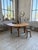 An antique dining table with a constructivist style, featuring a large, rounded top resting on a simple base with...
