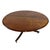 A vintage Regency style mahogany round dining table with a tripod pedestal base, ending on casters.