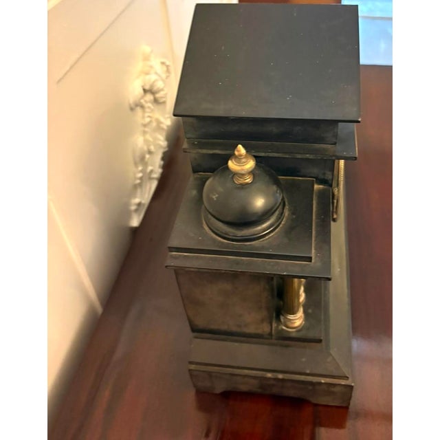 A striking antique French black marble and gilt brass architectural mantel clock dating from the late 19th century. The...