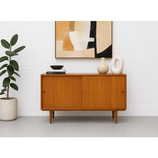 Mid Century Modern oak credenza featuring two sliding doors, solid light oak tapered legs and the simple and clean design...