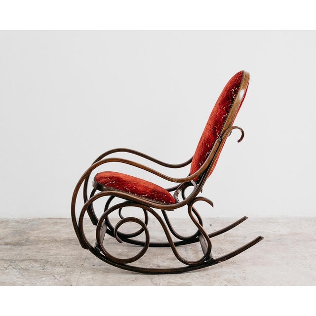 Charming rocking chair attributable to Thonet, a representative example of Mid-Century design. Made of steam-bent wood, it...