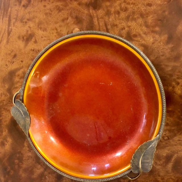 Rich orange enamel on copper dish with two leaves enhancing the decorative brass trim.