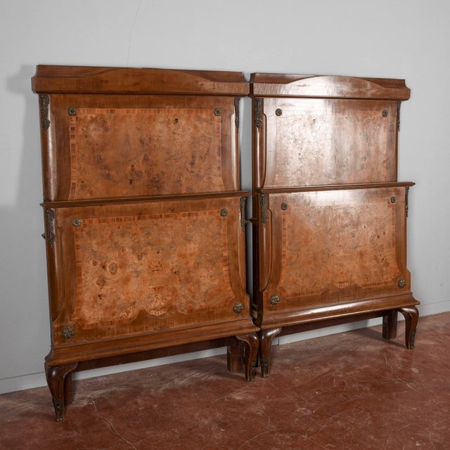 Discover this pair of vintage single beds, an example of refined craftsmanship combining functionality and historic...