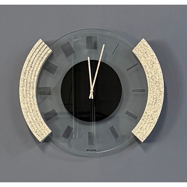 A bold postmodern wall clock signed "empire" on the glass face. Sculptural asymmetric side panels in speckled granite-look...
