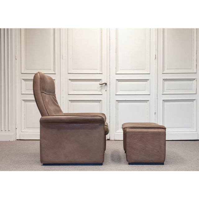 A refined 1960s lounge chair with matching ottoman by Swiss manufacturer De Sede. The set is fully upholstered in high-...