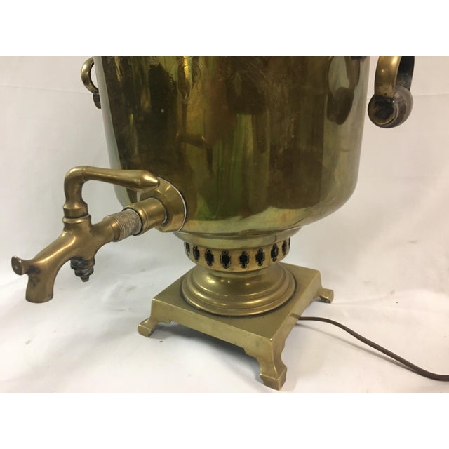 This large classic brass Russian Samovar features several hallmarks stamped in front, sturdy wooden handles and rests on a...